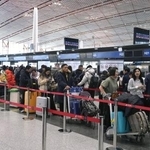 　春節に合わせた大型連休の初日、北京首都国際空港で日本便などをあつかうカウンターにならぶ人たち＝１５日（共同）