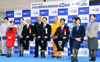 　全日空の国際線定期便就航４０周年式典で撮影に応じる全日空の井上慎一社長（中央）ら＝３日午前、成田空港