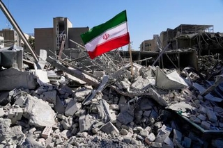 　３日、イランの首都テヘランで、攻撃を受けがれきとなった警察施設に立てられた国旗（ＡＰ＝共同）