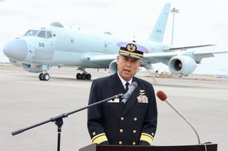　海自那覇航空基地に到着したＰ１哨戒機を背に記者会見する第５航空群の平木拓宏群司令＝５日午前、那覇市