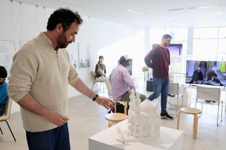 　日本各地のモスクの模型を解説する佐賀大のデルベル・ラミ助教＝４日、佐賀市