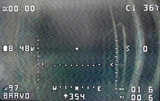 　離陸直前の超小型ドローンが搭載カメラで撮った原子炉格納容器内部。格納容器の壁（左側）や障害物（右）が見える＝５日午前（東京電力提供）