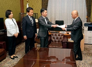 　衆院の築山信彦事務総長（右端）に赤字国債発行を可能にする独自の公債発行特例法案を共同提出する中道改革連合の伊佐進一氏（右から２人目）、国民民主党の田中健氏（同３人目）ら＝１０日午前、国会