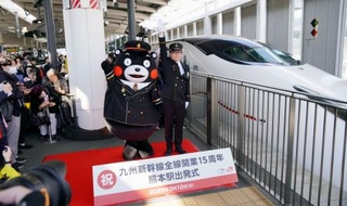 　九州新幹線全線開業１５周年を記念した出発式で、出発の合図を送る熊本県ＰＲキャラクター「くまモン」ら＝１２日午前、ＪＲ熊本駅