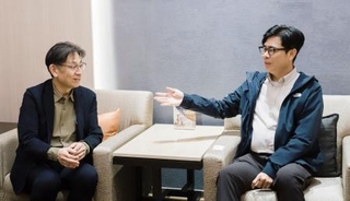 　会談する熊本県の竹内信義副知事（左）と高雄市の陳其邁市長＝１１日、台湾・桃園国際空港（高雄市提供・共同）