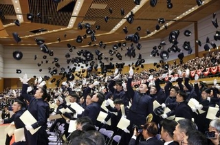 　防衛大学校の卒業式を終え、帽子を投げる卒業生＝１４日午前、神奈川県横須賀市