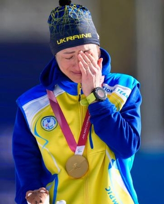　バイアスロン女子７・５キロ立位で獲得した金メダルを胸に、涙ぐむウクライナのオレクサンドラ・コノノワ＝７日、イタリア・テーゼロ（共同）