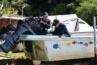 　転覆した船「平和丸」を調べる運輸安全委員会の事故調査官＝１８日午前、沖縄県名護市辺野古