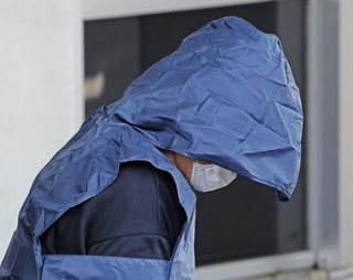 　送検のため、三重県警松阪署を出る水谷水都代容疑者（中央）＝２１日午後０時１２分