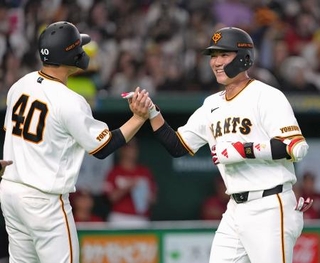 　６回、２ランを放ち、中山（左）とタッチを交わす巨人・坂本＝東京ドーム