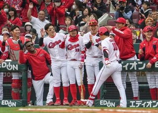 　１回、先制２ランの佐々木（手前）を迎える広島ナイン＝マツダ