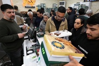 　イラン暦の正月を控え、買い物客でにぎわう菓子店＝２０日、テヘラン（共同）