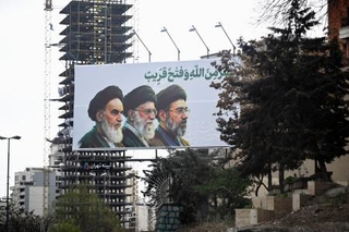 　街頭に掲げられたイランの最高指導者モジタバ・ハメネイ師（右）らの肖像＝２０日、テヘラン（共同）