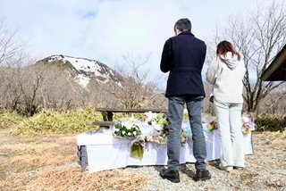 　２０１７年に雪崩が起きた斜面を見渡せる献花台を訪れた人たち＝２７日午前、栃木県那須町