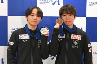 　メダルを手に撮影に応じる鍵山優真（左）と佐藤駿＝３１日、羽田空港