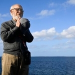 　米軍に撃沈された艦艇が沈む沖合に向かって手を合わせる遺族の吉田進さん＝１日午後、沖縄県宮古島市