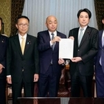 　衆院の築山信彦事務総長（中央）に企業・団体献金の規制を強化する政治資金規正法改正案を提出する中道改革連合と国民民主党の議員＝２日午後、国会