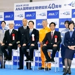 　全日空の国際線定期便就航４０周年式典で撮影に応じる全日空の井上慎一社長（中央）ら＝３日午前、成田空港