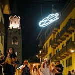 　イタリア・コルティナダンペッツォのメインストリートを、聖火を掲げて進むランナー＝３日（共同）