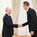 　４日、モスクワのクレムリンで握手するロシアのプーチン大統領（左）とハンガリーのシーヤールトー外務貿易相（タス＝共同）