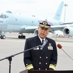 　海自那覇航空基地に到着したＰ１哨戒機を背に記者会見する第５航空群の平木拓宏群司令＝５日午前、那覇市