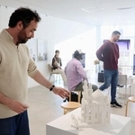 　日本各地のモスクの模型を解説する佐賀大のデルベル・ラミ助教＝４日、佐賀市