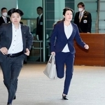 　閣議に遅れ、走って首相官邸に入る小野田経済安保相（右）＝６日午前