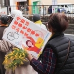 　「今日は家事も仕事も休みます」と書かれたプラカードを掲げて行進する女性ら＝６日午前、宇都宮市