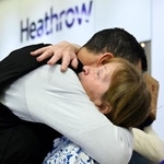 　６日、英ロンドンのヒースロー空港で、オマーンから到着後に抱擁される乗客（ロイター＝共同）