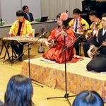 　演奏会で三線を弾く西原圭佑さん（右）＝７日、北京の日本大使館（共同）