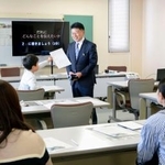 　東日本大震災にちなんだ広告企画を教材に模擬授業をする光武正夫さん（中央）＝７日午後、佐賀市