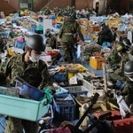 　宮城県山元町の小学校には、津波により持ち主が不明となった写真や位牌、ランドセルなどが大量に保管されていた。自衛隊員が思い出の品に付いた泥やほこりを丁寧に落としていた＝２０１１年４月