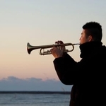 　福島県富岡町の海岸でトランペットを演奏する福田純也さん＝１１日午前６時３分