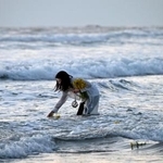 　東日本大震災で被災した福島県いわき市の薄磯海岸で、花を手向ける女性＝１１日午前５時４７分