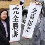 　判決後、垂れ幕を掲げる原告側の弁護士＝１２日午後、新潟市