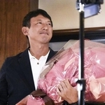 　熊本県八代市長選で初当選を果たし、花束を手に笑顔の小野泰輔氏＝２０２５年８月、八代市