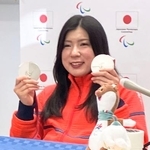 　記者会見し、アルペンスキー女子座位で獲得した銀メダル２個を手にする村岡桃佳＝１３日、イタリア・コルティナダンペッツォ（共同）