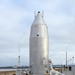 　報道陣に公開された小型実験機「ＲＶ-Ｘ」。機体の準備を完了していたが、午後飛行試験の延期が発表された＝１４日午前、秋田県能代市