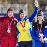 　金メダルを獲得したバイアスロン女子７・５キロ立位の表彰台で、ポーズをとるウクライナのオレクサンドラ・コノノワ（中央）＝７日、テーゼロ