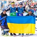 　ノルディックスキー距離混合１０キロリレーで銀メダルを獲得し、国旗を掲げるオレクサンドラ・コノノワ（左から２人目）らウクライナ選手＝１４日、イタリア・テーゼロ（共同）