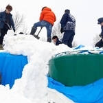 　雪山からタンクを掘り出す高砂酒造の社員ら＝１９日午前、北海道美瑛町