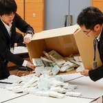 　茨城県神栖市長選を巡り、再点検する票を箱から取り出す職員＝２１日午前、水戸市