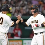 　６回、２ランを放ち、中山（左）とタッチを交わす巨人・坂本＝東京ドーム