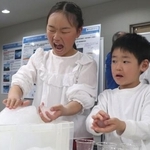 　南極について学ぶイベントで、氷に触れる子どもたち＝２１日午後、広島市中区