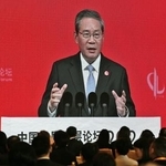 　「中国発展フォーラム」で演説する中国の李強首相を映す大型画面＝２２日、北京（共同）