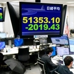 　下げ幅が一時２０００円を超えた日経平均株価を示すモニター＝２３日午前、東京都港区の外為どっとコム