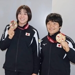 　柔道のグランドスラム・トビリシ大会から帰国し、メダルを手に笑顔の嘉重春樺（右）と田中志歩＝２３日、成田空港