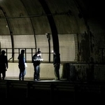 　新名神高速道路下り線の野登トンネル出口付近を調べる捜査員＝２４日夜、三重県亀山市