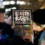 　国会前でプラカードを掲げ、憲法改正の動きなどに抗議する人たち＝２５日夜