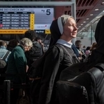 　２５日、米ニューヨークのケネディ国際空港で、チェックインのための列で待つ人たち（ゲッティ＝共同）